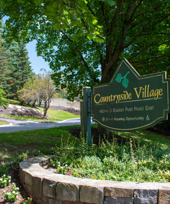 a sign that says campus village with a building in the background