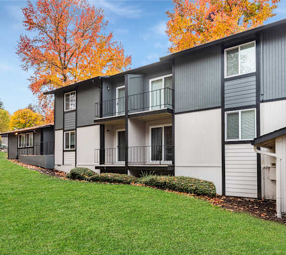 Exterior view of Rolling Hills' two story apartment building surrounded by a large green lawn in Tualatin, OR