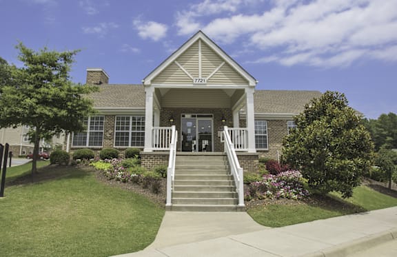A house with a front porch and a well-maintained lawn.