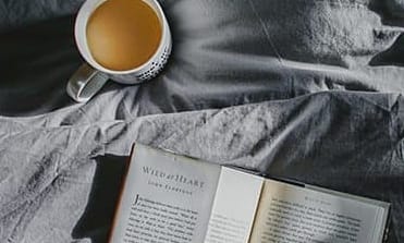 Coffee and book on bed