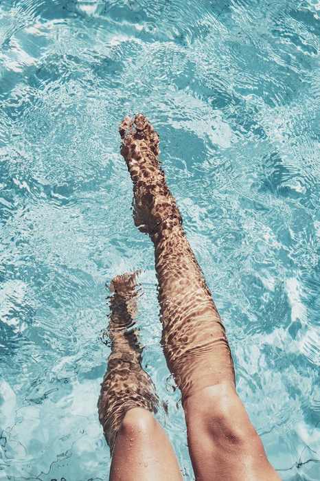 A person's legs sticking out of the water.