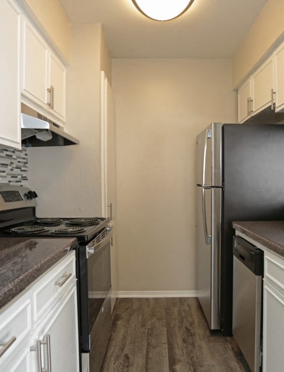 a kitchen with white cabinets and stainless steel appliances