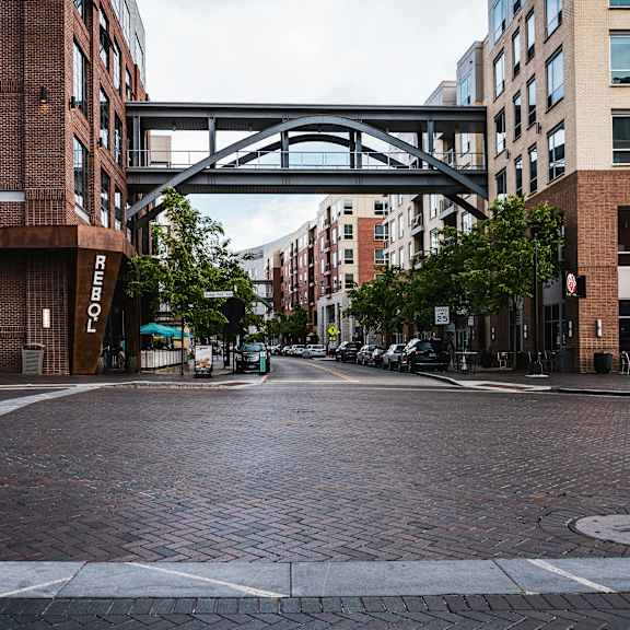 an empty city street with a bridge in the middle