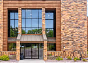 Thumbnail 1 of 26 - the front of a brick building with a glass door