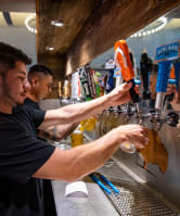 a bartender filling a glass of beer at a bar