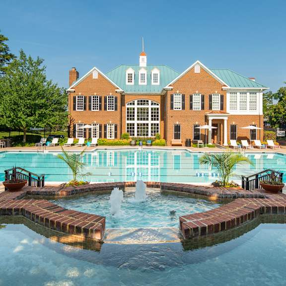 A large building with a pool in front of it. at Fairfax Square Apartments, Fairfax, VA, 22031