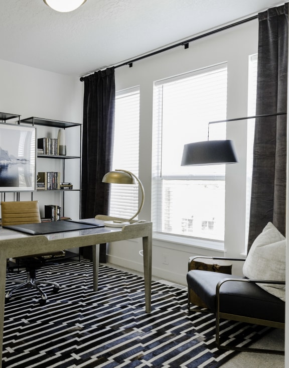 a home office with a desk and bookshelves in a 555 waverly unit