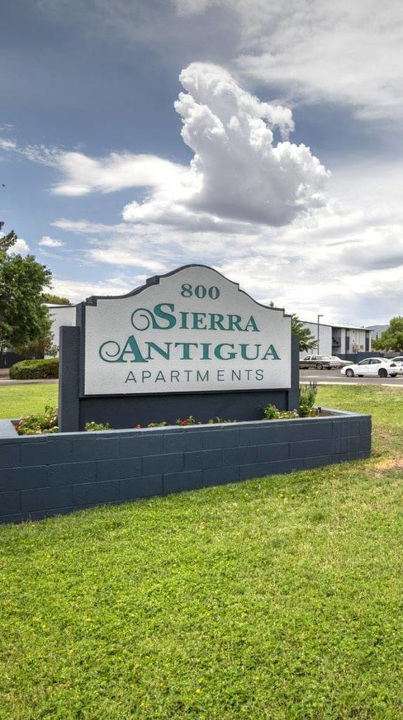 a large sign with the name of the apartment complex in front of it