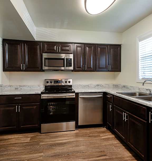 A kitchen with dark brown cabinets and stainless steel appliances.