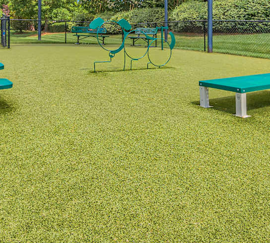 A park with a green lawn and a red fire hydrant.