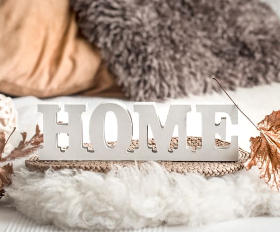 a home sign on a couch with christmas decorations