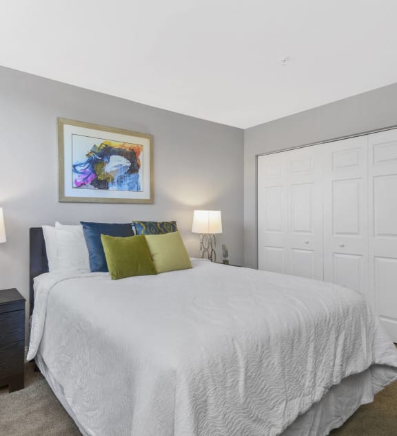 a bedroom with a white bed and a closet