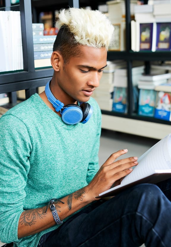 this is a photo of a young man reading at the local bookstore.