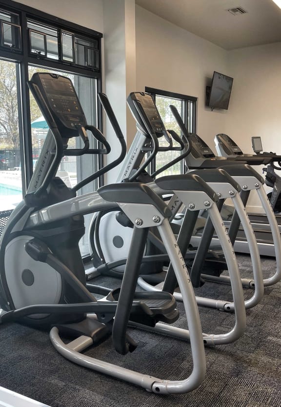 a gym with a row of exercise machines and a window at 2300 West Apartments, Nevada, 89502