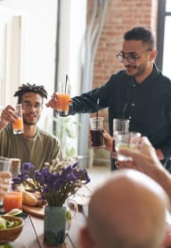 A group of people are toasting with drinks at a dinner table. at The Verandas, Tacoma, 98466