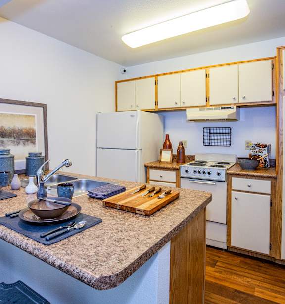 A kitchen with a table set for two and a painting on the wall.