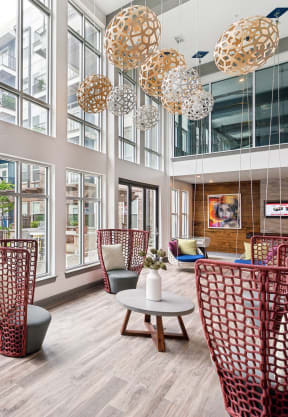 a lobby with red wicker chairs and a blue wall with large windows at Glenwood at Grant Park Apartments, Atlanta, 30316