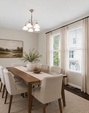 A dining room with a wooden table and chairs.