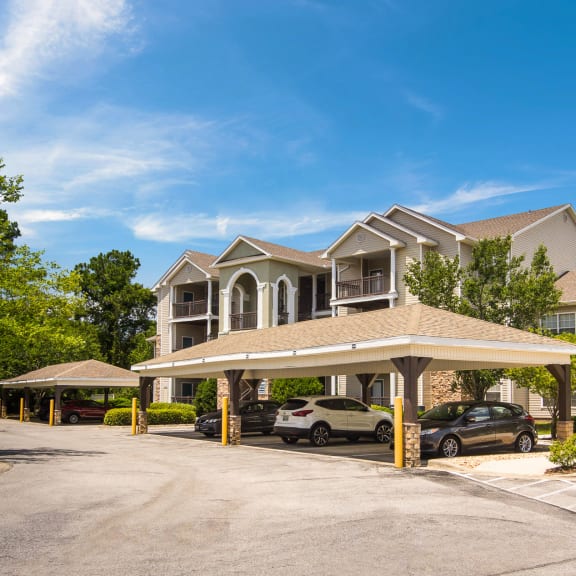 Covered parking spaces by the apartment buildings at Angel Landing Apartment Homes in Pensacola, FL