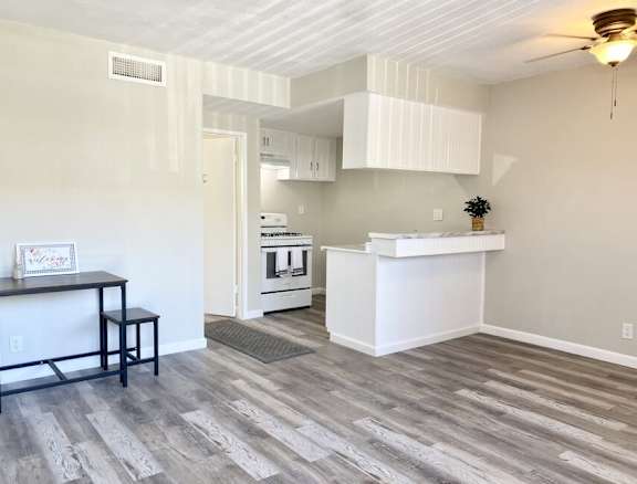 an empty living room with a kitchen in the background at South Pointe Apts, Covina California