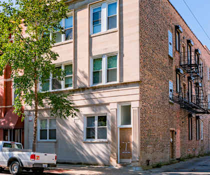a building on a city street with cars parked in front of it