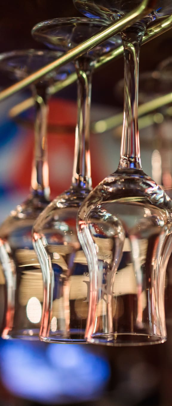 a row of wine glasses hanging from a rack