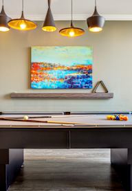 a pool table in a room with a painting on the wall
