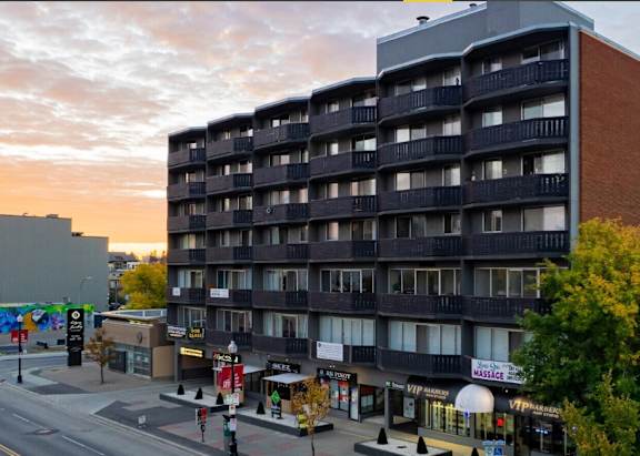 Apartment building with a walkway in front.