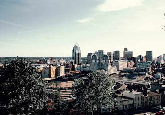 A cityscape with a mix of modern and older buildings, with a clear sky above.