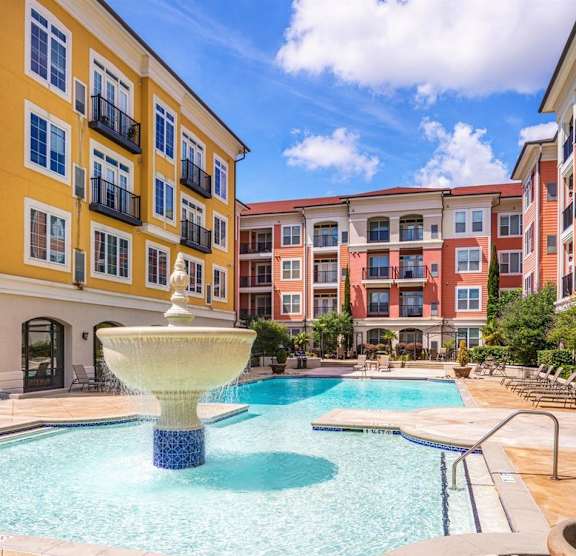 A pool with a fountain in the middle of it.