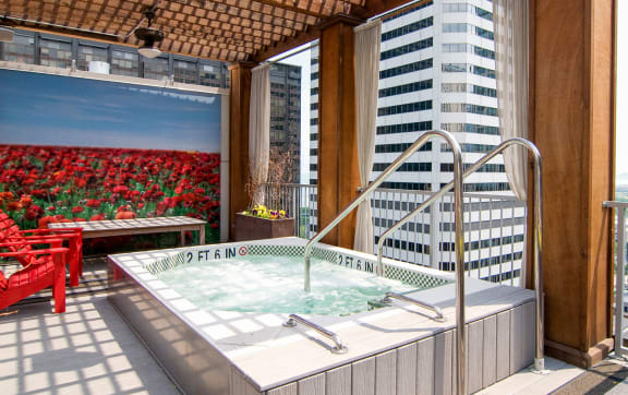 a jacuzzi on the balcony of a skyscraper with a city view