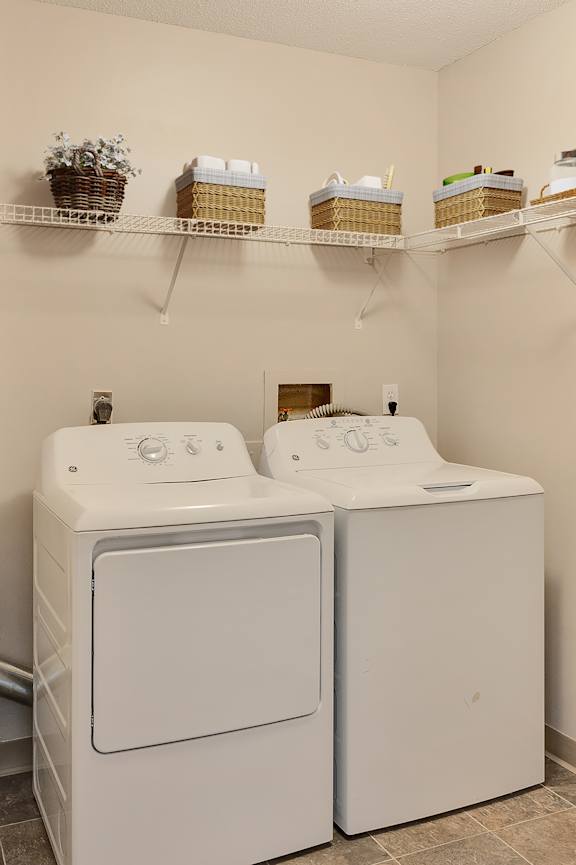 A white washer and dryer in a small laundry room. at Crosby Pointe Apartments, Minnesota, 55116-3244
