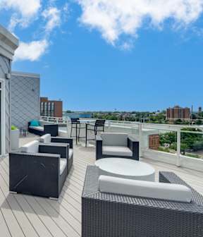 A patio with a table and chairs overlooking a cityscape.