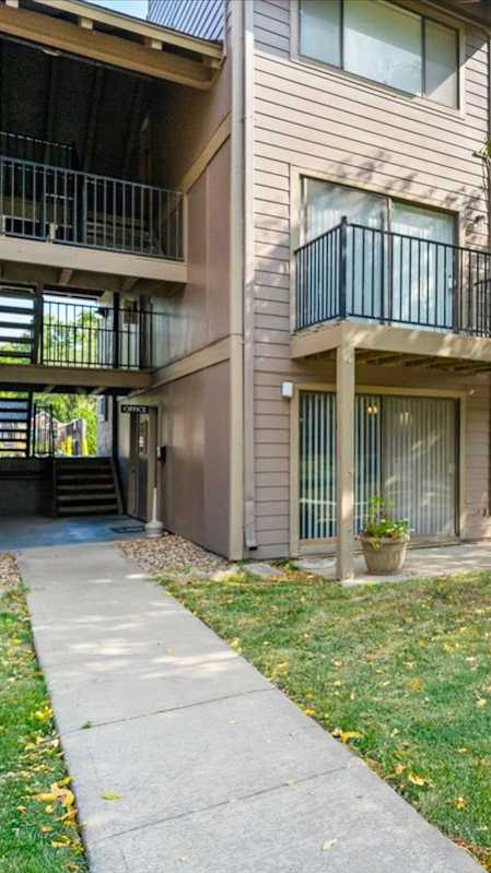 Balcony with a table and chairs overlooking a pool at Bremerton Park Apartment Homes , Prairie Village, Kansas