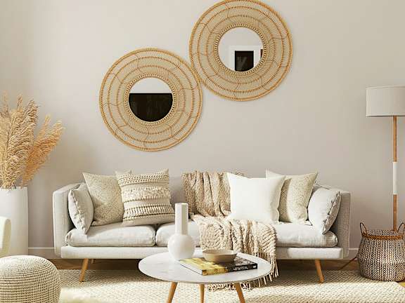 A living room with a white couch, a white chair, a white coffee table, and a white rug.