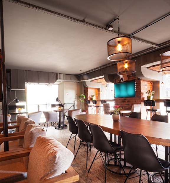 A modern dining area with wooden tables and chairs.