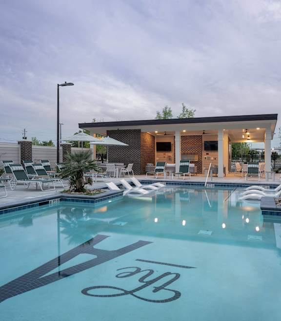 a swimming pool with lounge chairs and a building with a pool