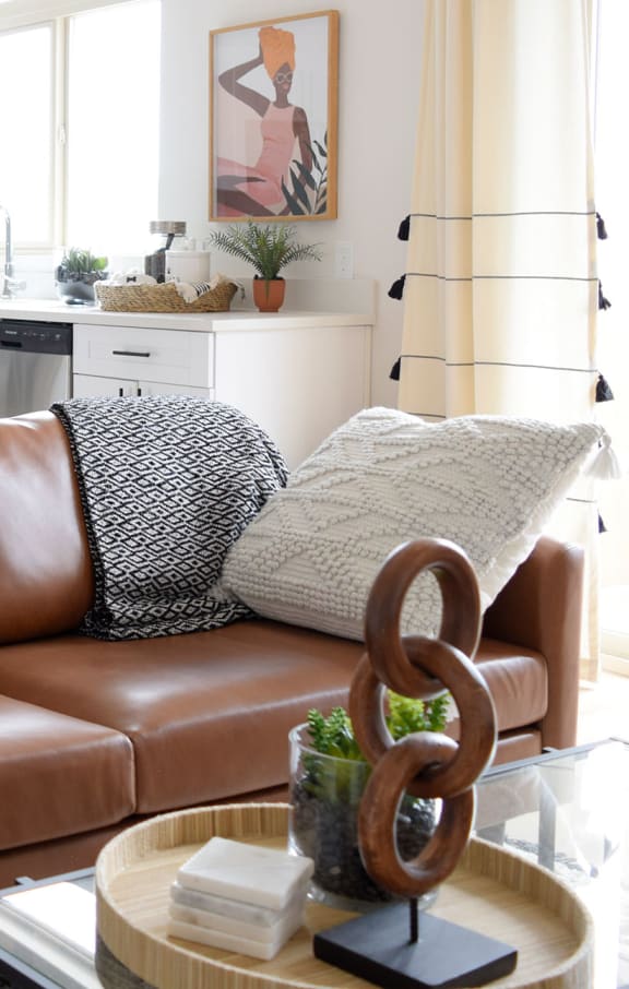 a living room with white walls and a brown leather couch