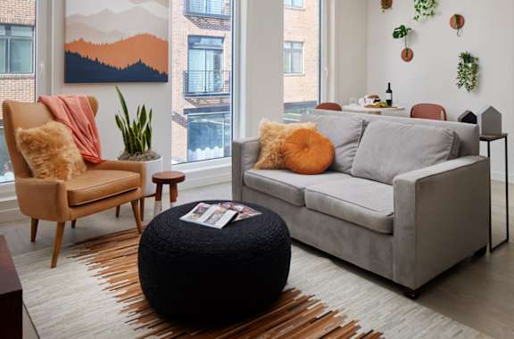 a living room with a couch and chairs and a rug