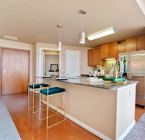 A kitchen with a white counter and bar stools.