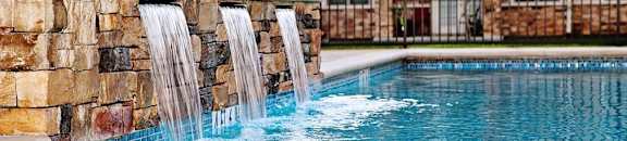A pool with a waterfall feature in the middle of it.