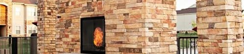 A brick fireplace with a grill on the patio.