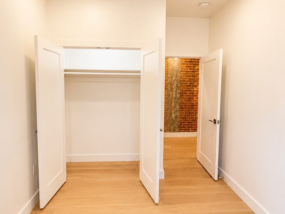 A hallway with a brick wall and white walls.