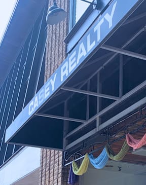 A realty sign is hanging on a building.