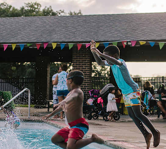 a group of children jumping into a swimming pool at Walnut Crossings in Monroeville, PA 15146