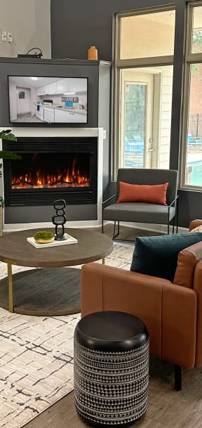 a living room with a fireplace and chairs and a table