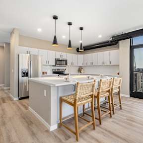 A modern kitchen with wooden floors and furniture.