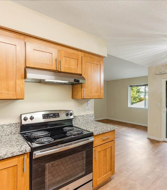 A kitchen with wooden cabinets and a black stove top oven.