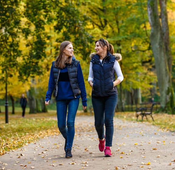 two women walking down a path in a park