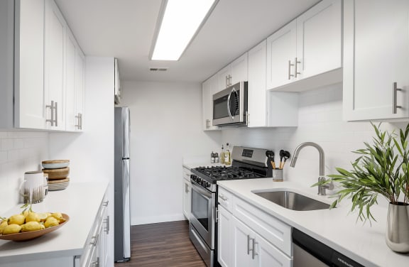 a kitchen with white cabinets and stainless steel appliances